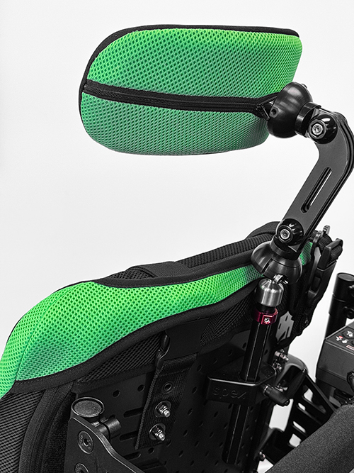 Side shot of manta back support with green covers and head support, showing harness retainers keeping the trunk support in place.