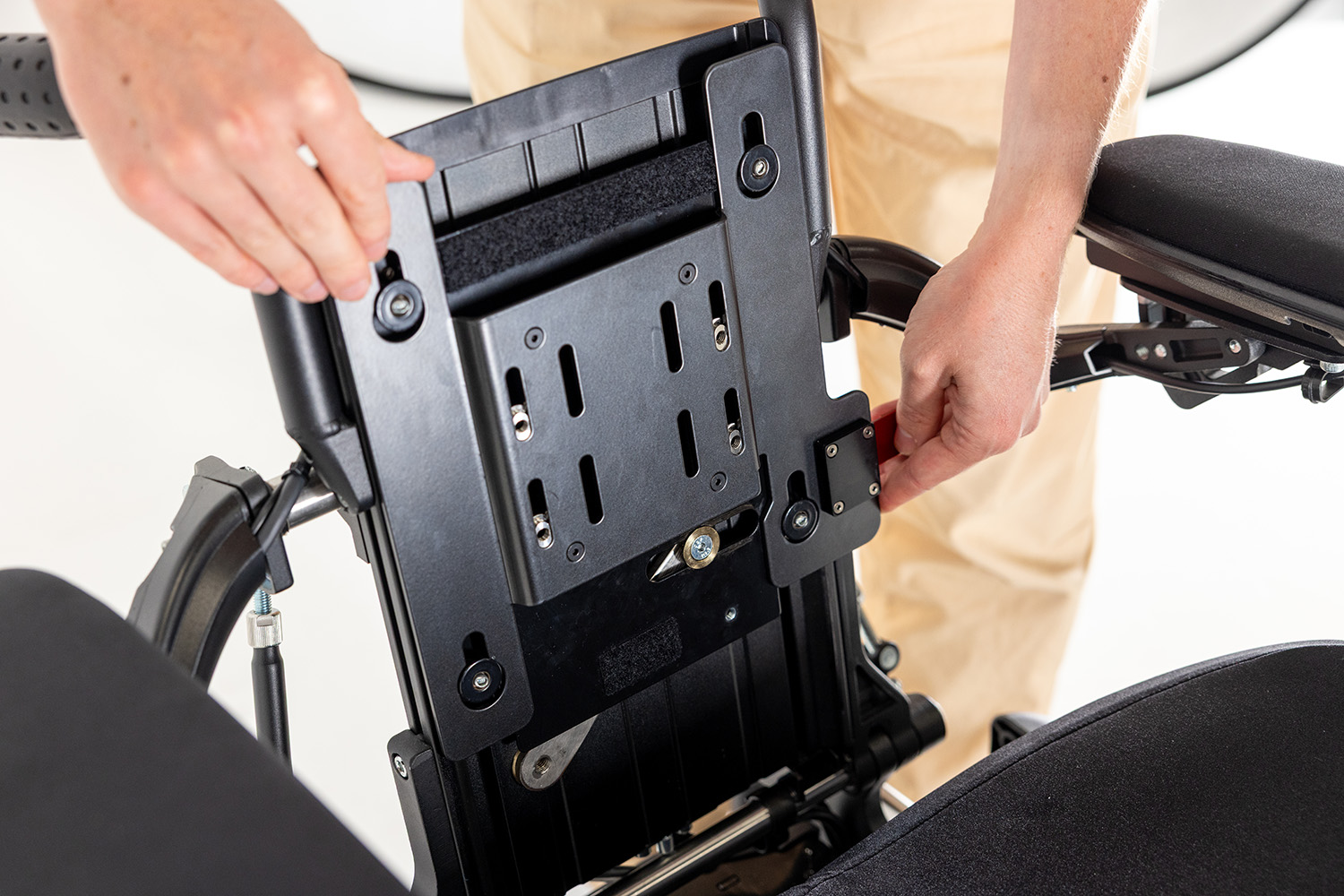 Back support mount for permobil corpus.Hands place the slim mount on the backrest.