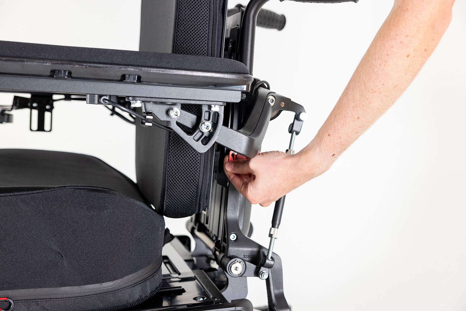 Close up of the Spex Permobil back support hardware mount showcasing increase seat depth on a black permobil chair. A hand adjusts the backrest.