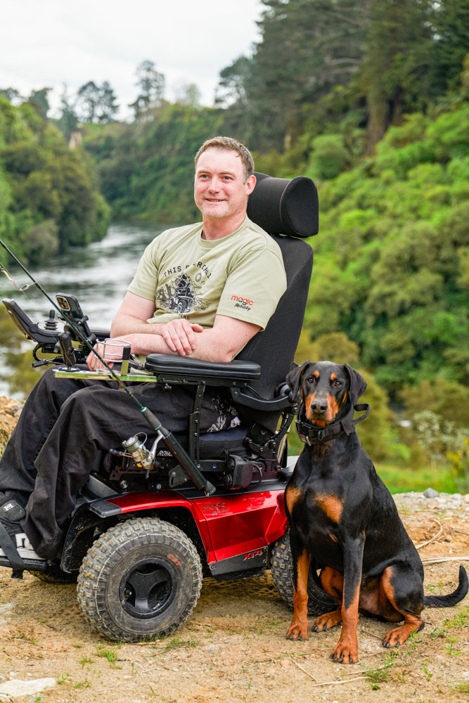 Philip uses a Magic Mobility XT4 powerchair outdoors as he poses with his dog, having reliable all?terrain performance.