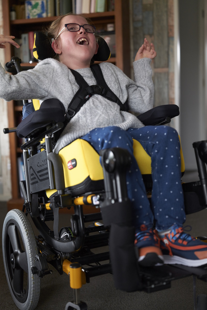 Front view of girl in yellow spex wheelchair.