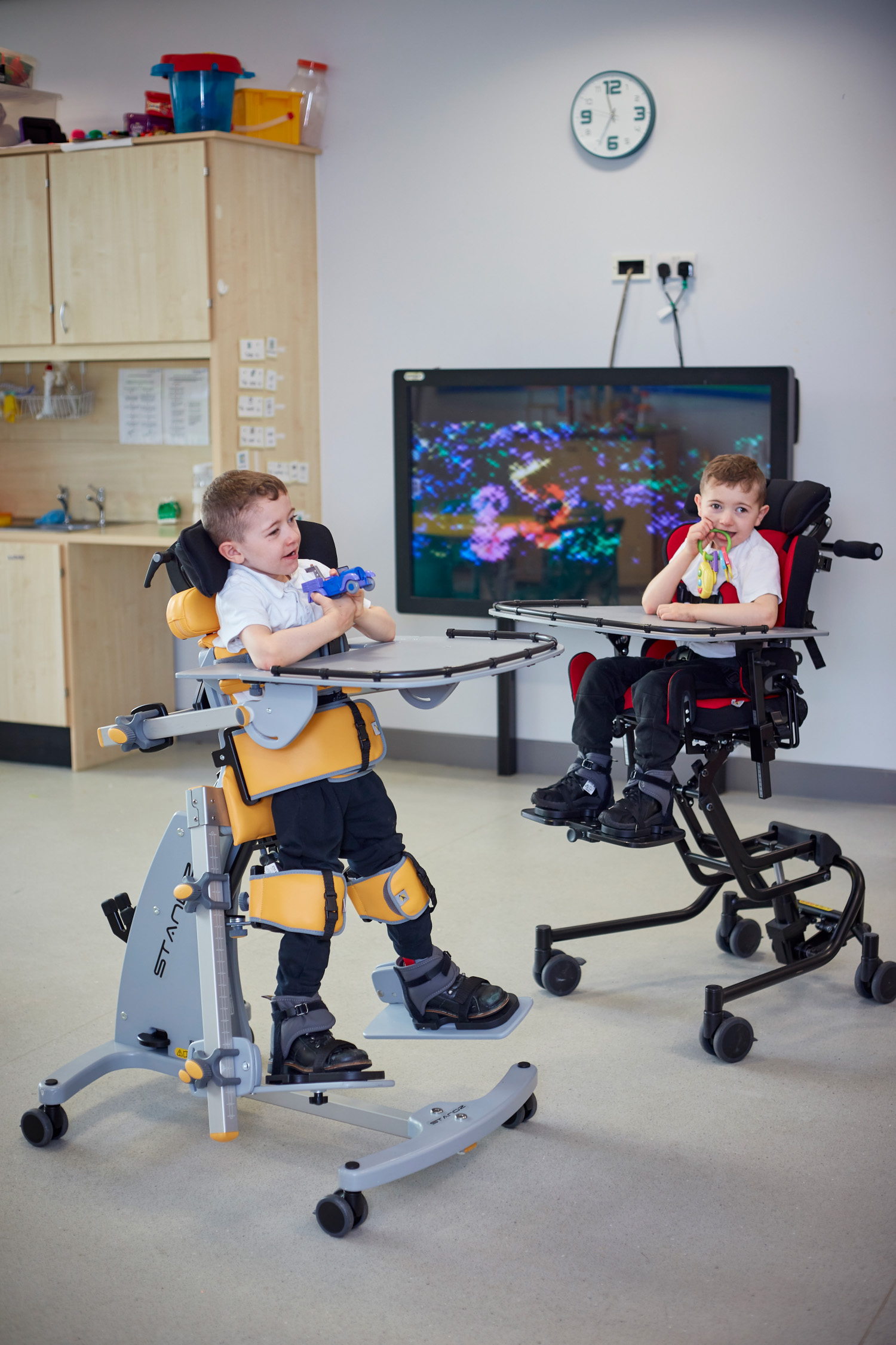 two boys in pediatric highchairs play.